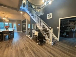 Clean two-story home interior with hardwood floors, white staircase, and bright open living space