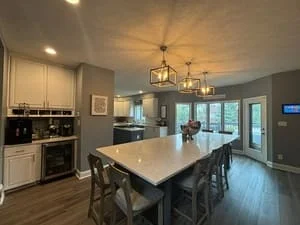 Clean modern kitchen with white cabinets, stainless appliances, and dining table with chairs