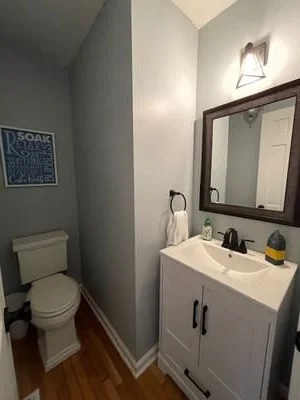 Clean bathroom with white vanity, dark-framed mirror, organized countertops, and polished fixtures