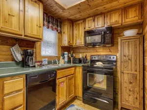 Clean wooden kitchen cabinets, organized countertops, and polished black stove and oven