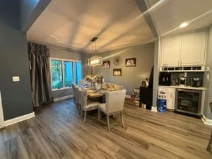 Clean open-concept living room with hardwood floors, white cabinetry, and modern furnishings
