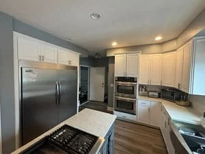 Clean kitchen with white cabinets, stainless steel appliances, gas cooktop, and hardwood floors